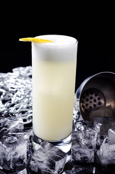 Alcoholic Cocktail - Bebida de pájaro amarillo con limón en rodajas en un vaso con hielo de cubo en una coctelera sobre un restaurante de fondo negro. Alcohol bar, espacio de copia . — Foto de Stock