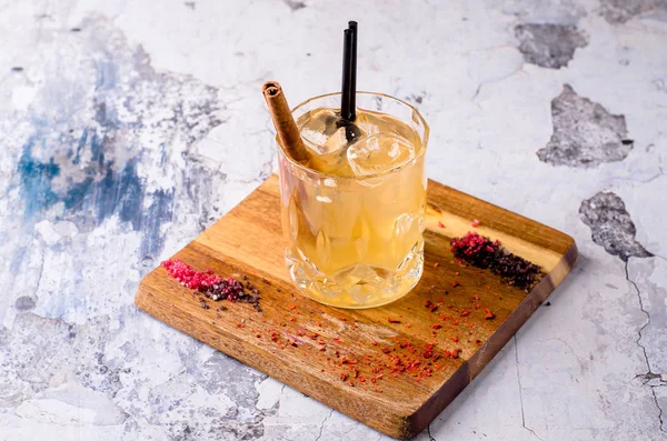 Yukarı, viski, buz küpleri dekorasyon ahşap bir masa, gri arka plan üzerinde kahverengi alkollü kokteyl kapatın. Bar alkol menüsü, akşam için güçlü içki. Metin tasarım, seçici odak için alan.