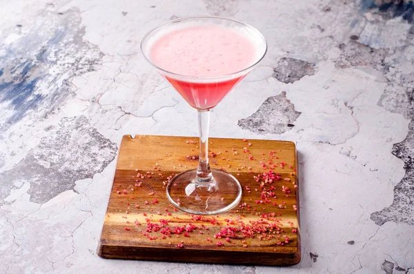 Top view cocktail rosa rosso Cosmopolitan fresco in un bicchiere da martini su un tavolo di legno, sfondo grigio. Bar menu bevande alcoliche, deliziosa tequila sunrise long drink . Immagini Stock Royalty Free