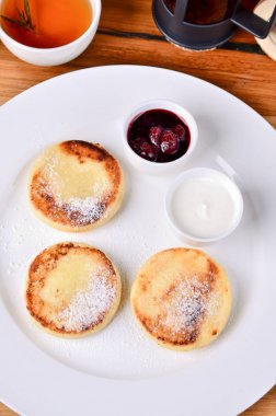 Geleneksel Rus kahvaltı kiraz reçeli, ekşi krema ve siyah çay süzme peynir kızarmış. Üstten Görünüm peynirli gözleme, yakın.