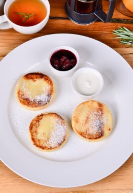 Geleneksel Rus kahvaltı kiraz reçeli, ekşi krema ve siyah çay süzme peynir kızarmış. Üstten Görünüm peynirli gözleme, yakın.