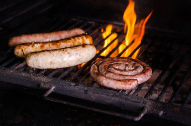 Alevli ızgara ızgara sosis. Barbekü ile ateşli arka plan, yakın çekim