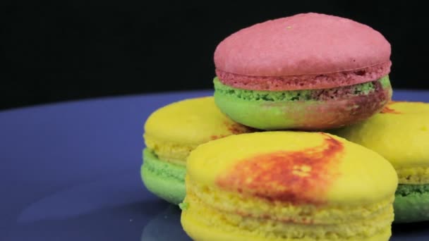Multicolored macaroon revolve a clockwise on a dark background, close-up — Stock Video