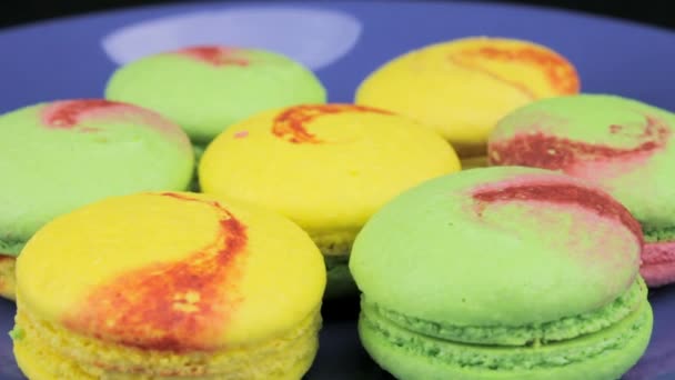 Színes macaroon forog egy kék tányérra — Stock videók