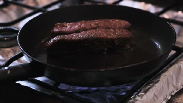 The chef puts beef meat on a hot frying pan — Stock Video