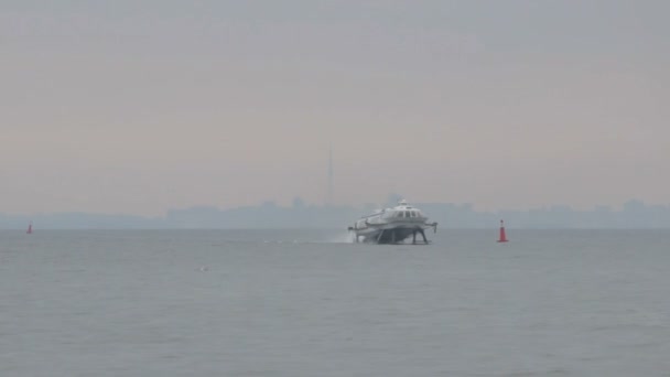 Пассажирское судно быстро плавает по реке на фоне города — стоковое видео