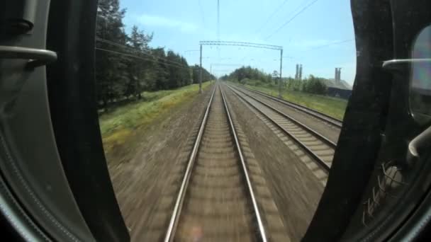 Vista de um trem em movimento nos trilhos e travessas, passagem sob ponte — Vídeo de Stock