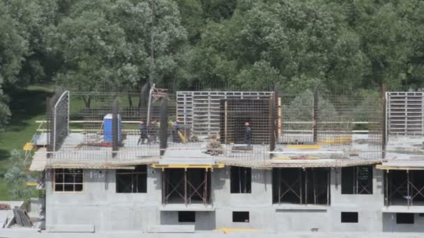 Equipo de constructores que trabajan en la construcción de un muro en un edificio en construcción — Vídeos de Stock