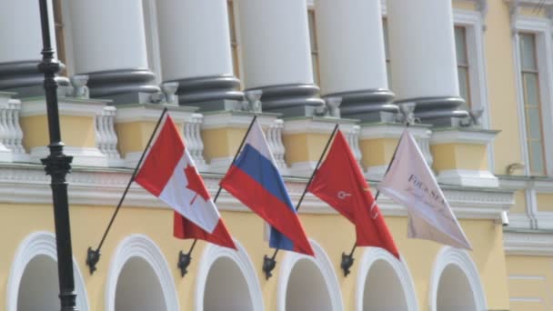 Saint Petersburg, Rusya Federasyonu - 1 Temmuz 2016: Rusya ve flutters bir bina Rüzgardaki bayrak Kanada yakın çekim — Stok video