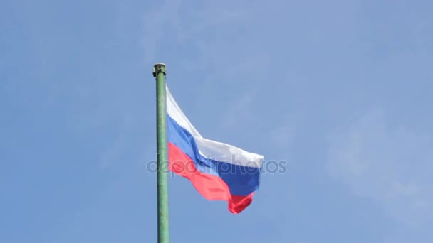 Limpiar brillando bandera rusa ondea en el viento en el asta de la bandera en el fondo del cielo azul — Vídeos de Stock
