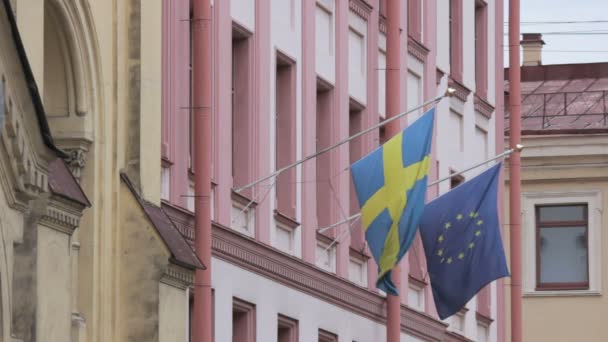 Banderas suecas y de la Unión Europea ondeando en el viento sobre el edificio del Consulado General de Suecia, San Petersburgo — Vídeo de stock