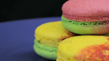 Yavaş yavaş dönen karanlık bir arka plan karşı çok renkli acıbadem kurabiyesi