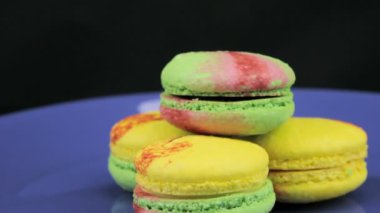 Renkli acıbadem kurabiyesi yavaş yavaş koyu arka plan üzerinde bir saat yönünde döndür