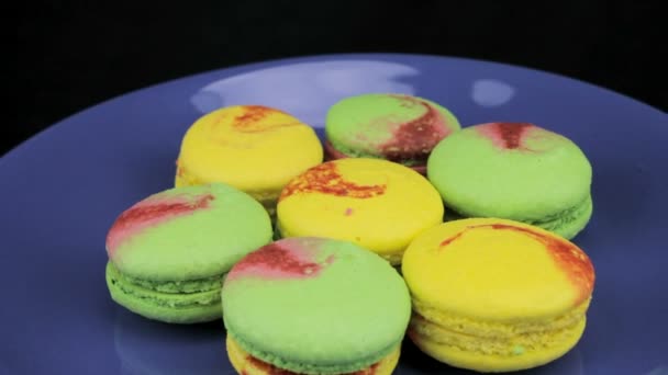 Macaron colorato ruotare lentamente sulla piastra blu — Video Stock
