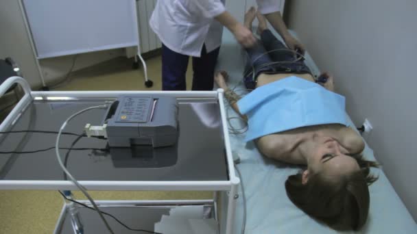 Cardiólogo médico fija sensores en chica, cardiograma — Vídeo de stock