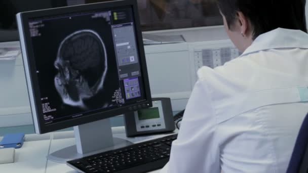 El médico trabaja en el ordenador con la imagen del cerebro en tiempo real — Vídeos de Stock