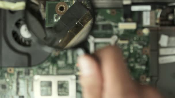 Engineer inspects laptop motherboard under the magnifying glass — Stock Video