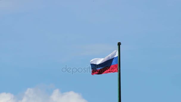 Bandera rusa ondea en el viento en el asta de la bandera sobre el fondo azul del cielo — Vídeos de Stock