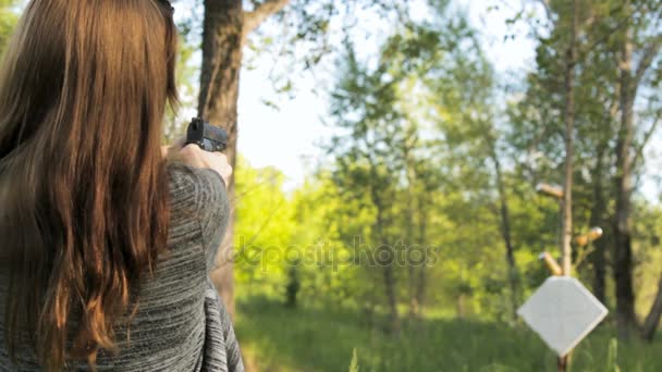 Ragazza spara una pistola a un bersaglio sulla natura — Video Stock