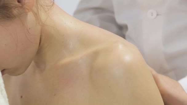 Массажист массирует шею и плечи девушки — стоковое видео