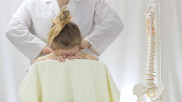 Médico masajista en una sala de masajes masajea el cuello y las niñas — Vídeo de stock