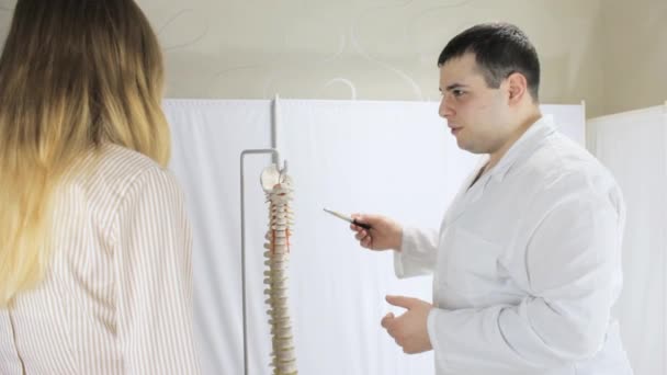 Doctor ukazuje pacientů bolavých míst na páteři rozložení — Stock video