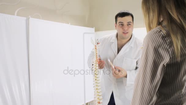 Medical teacher tells student about structure of the vertebrae in spine — Stock Video