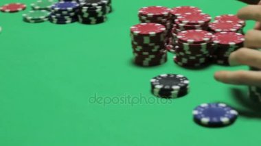 Yeşil bir masada oturan poker oyuncuları