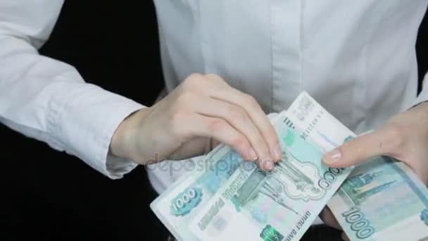 Mulher conta hesitantemente o dinheiro e pilhas de notas em uma imagem, rublos russos — Vídeo de Stock