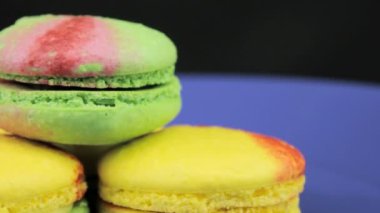 Sarı ve yeşil acıbadem kurabiyesi döndürmek koyu arka planı