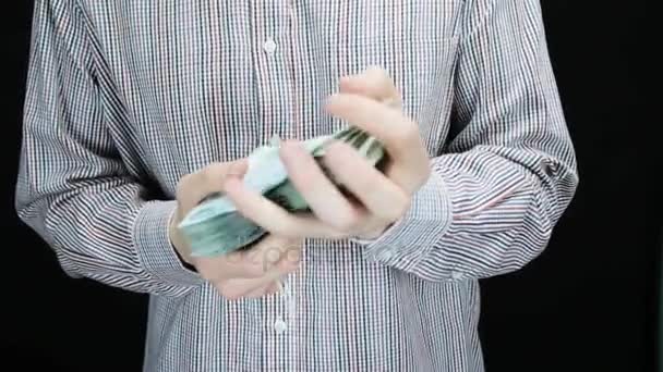 A man counts money, ties it and puts into a pocket — Stock Video