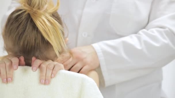 El médico hace masaje de la columna superior de una mujer joven — Vídeo de stock