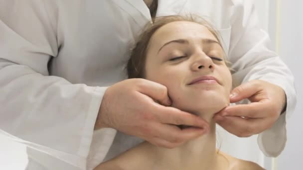 Young girl smiles from the face massage, hands massage — Stock Video