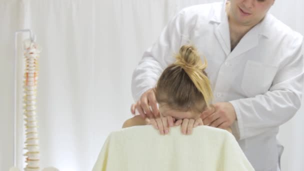 Arzt massiert junge Frauen in Klinik an der oberen Wirbelsäule — Stockvideo