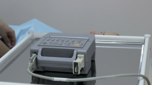 Kardiolog läkare installerar sensorer och aktivera ett elektrokardiogram kardiogram enhet — Stockvideo