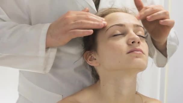 Massage van het voorhoofd en het gezicht van een jong meisje — Stockvideo