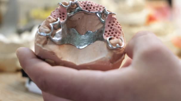 The layout of the denture in the hands of man and a work desk prosthodontist — Stock Video