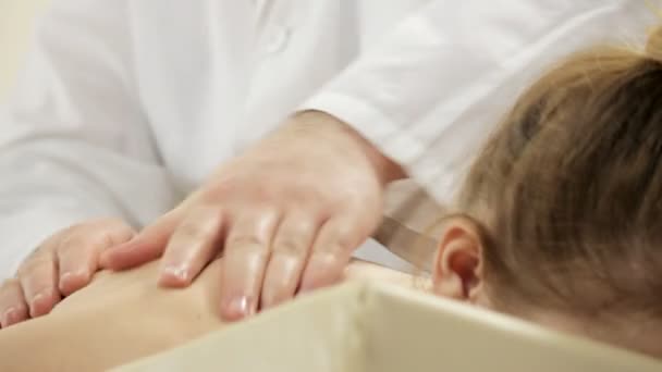 医生按摩师为一个年轻的女孩做肩部按摩 — 图库视频影像