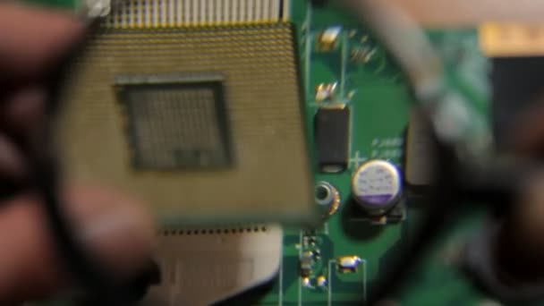 A tomada e o processador do computador portátil abaixo de uma lupa — Vídeo de Stock