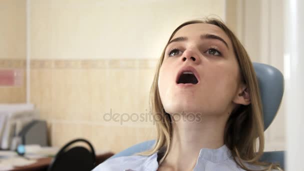 Meisje met de mond open in de tandarts stoel — Stockvideo