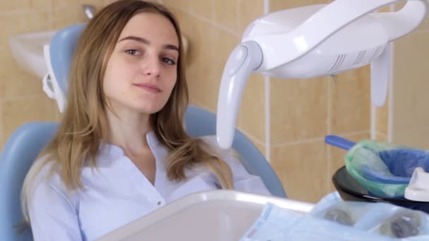 Девушка в кресле-стоматологе посылает воздушный поцелуй в камеру — стоковое видео
