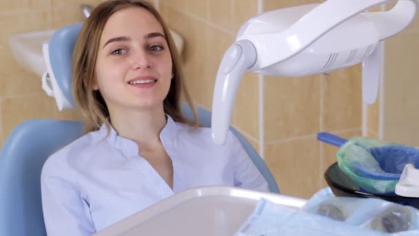 Пациент в кабинете дантиста плюется в корзину — стоковое видео