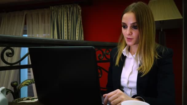 Zakelijke meisje in blouse en jas praten over video verbinding via laptop — Stockvideo