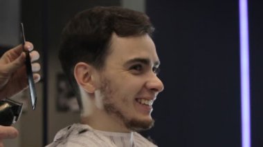 Genç adam bir düzeltici ve fırçalar, yan görünümü ile berber keser