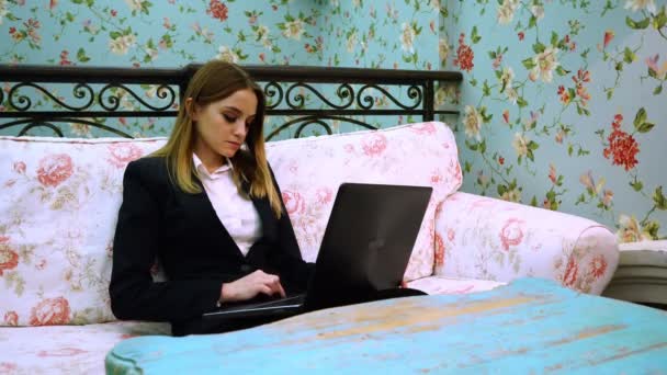 Giovane donna d'affari seduta su un comodo divano e digitando su un testo del computer portatile — Video Stock