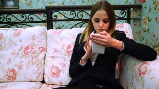 The girl in a business suit communicates on social networks on a phone — Stock Video