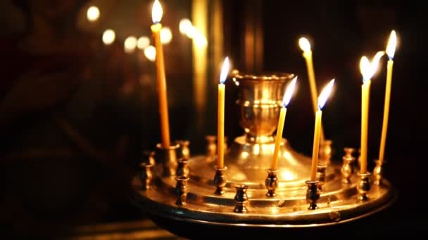 Ο άνθρωπος διορθώνει τα κεριά κάψιμο στο το κερί πριν το Άγιο πρόσωπο στη χριστιανική εκκλησία — Αρχείο Βίντεο