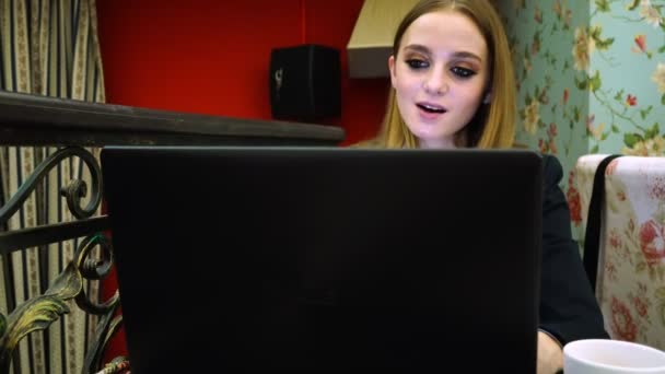 Businessgirl in Bluse und Jacke spricht im Video, wenn sie den Laptop benutzt — Stockvideo