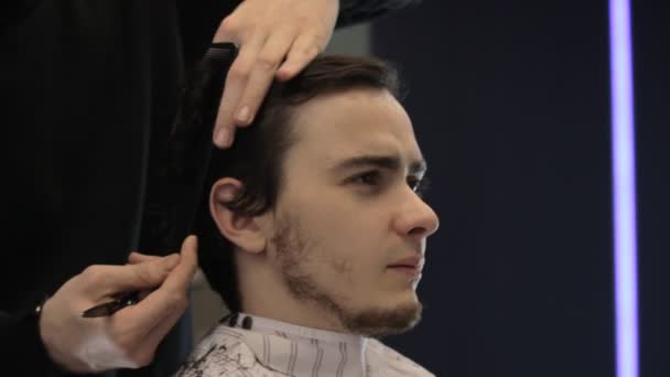 Молодий чоловік порізав волосся ножицями — стокове відео