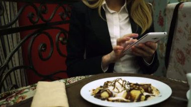 İş kadını restoranda bir smartphone kullanarak bir mesaj yazmış